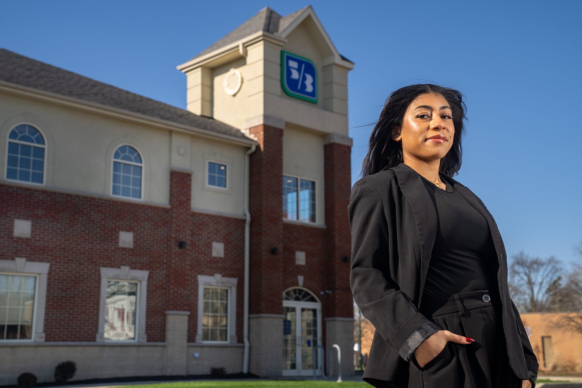 A person in a suit poses for a picture in front of Fifth Third Bank
