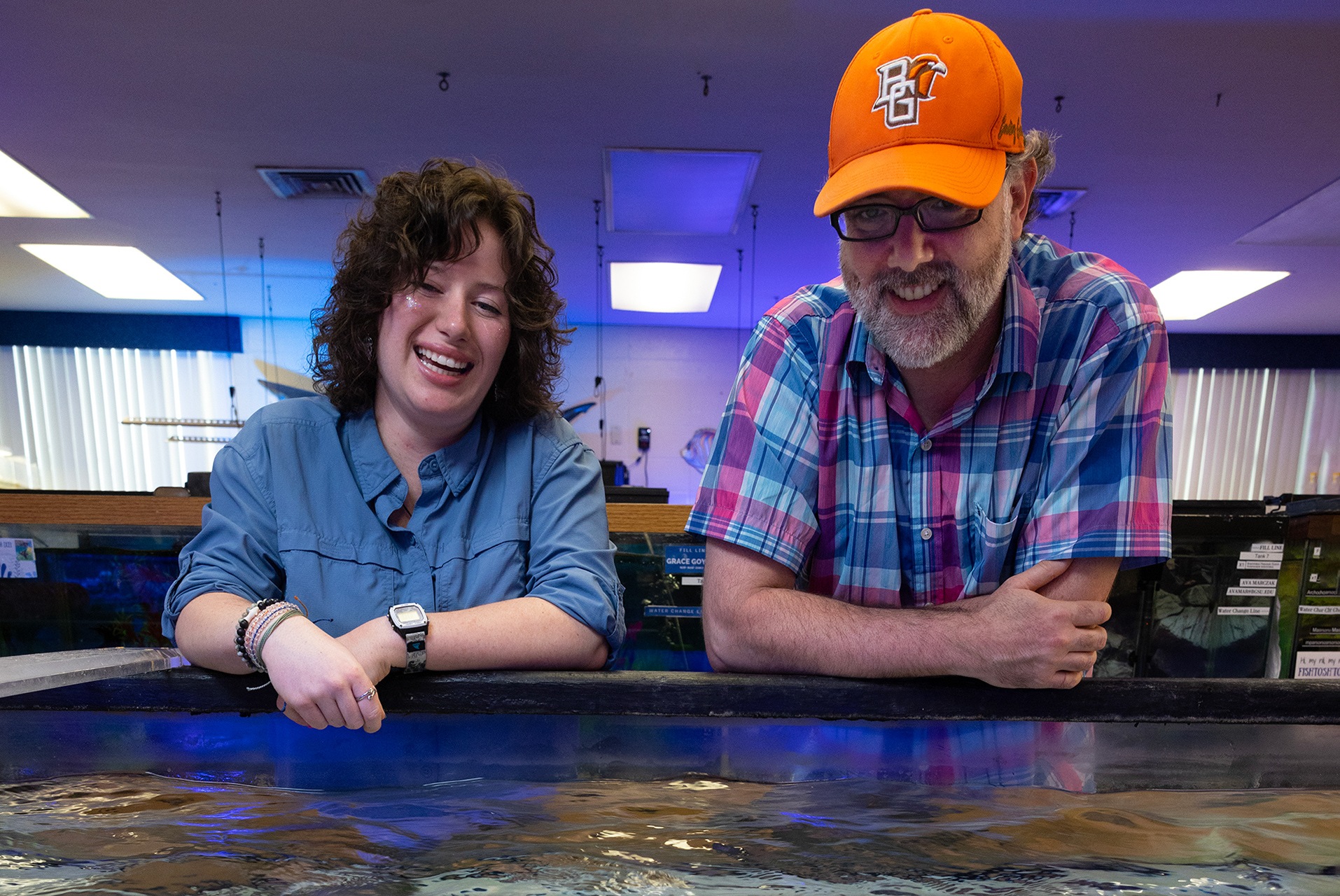 A student and professor talk in a laboratory.