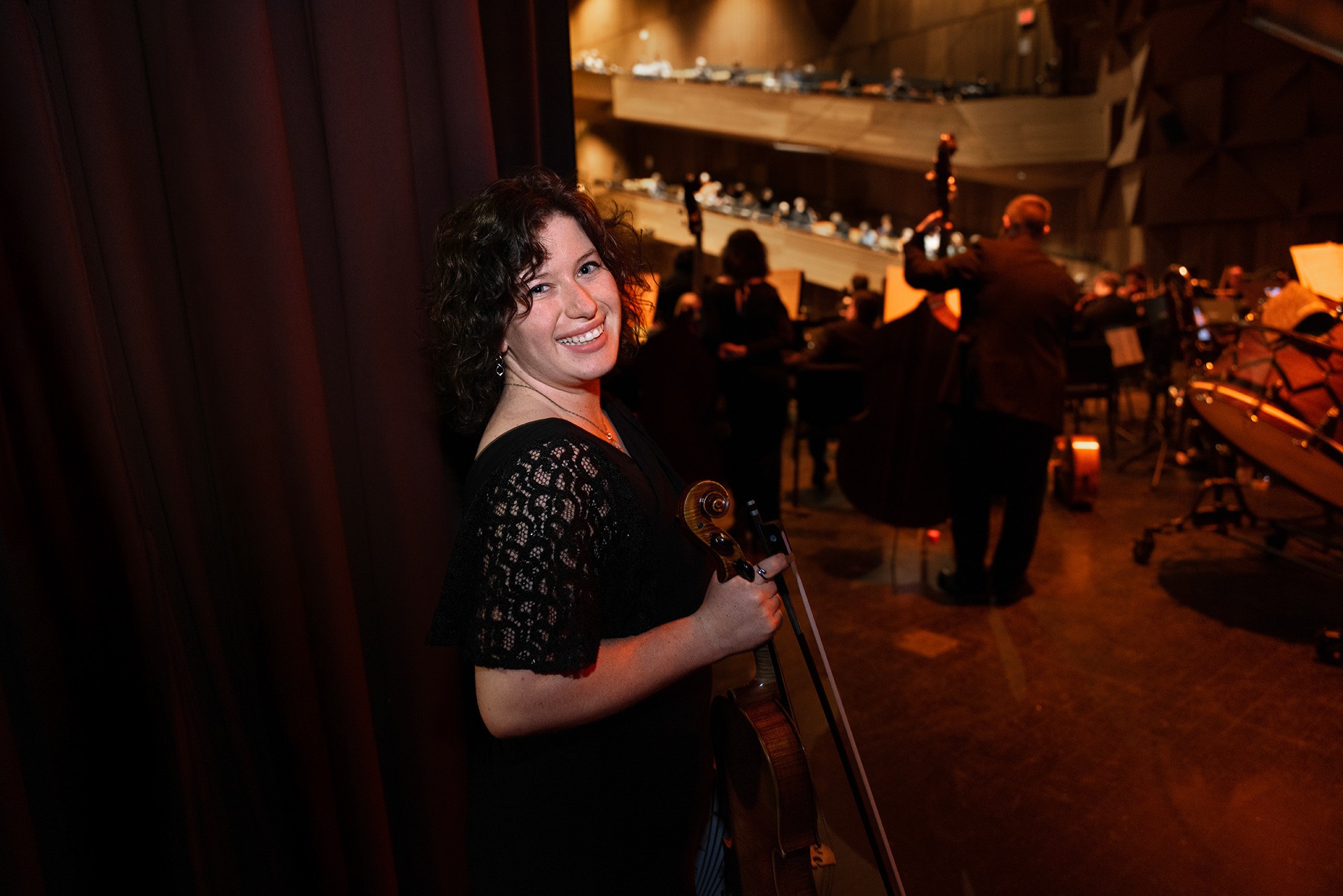 A viola player smiles before going on stage.
