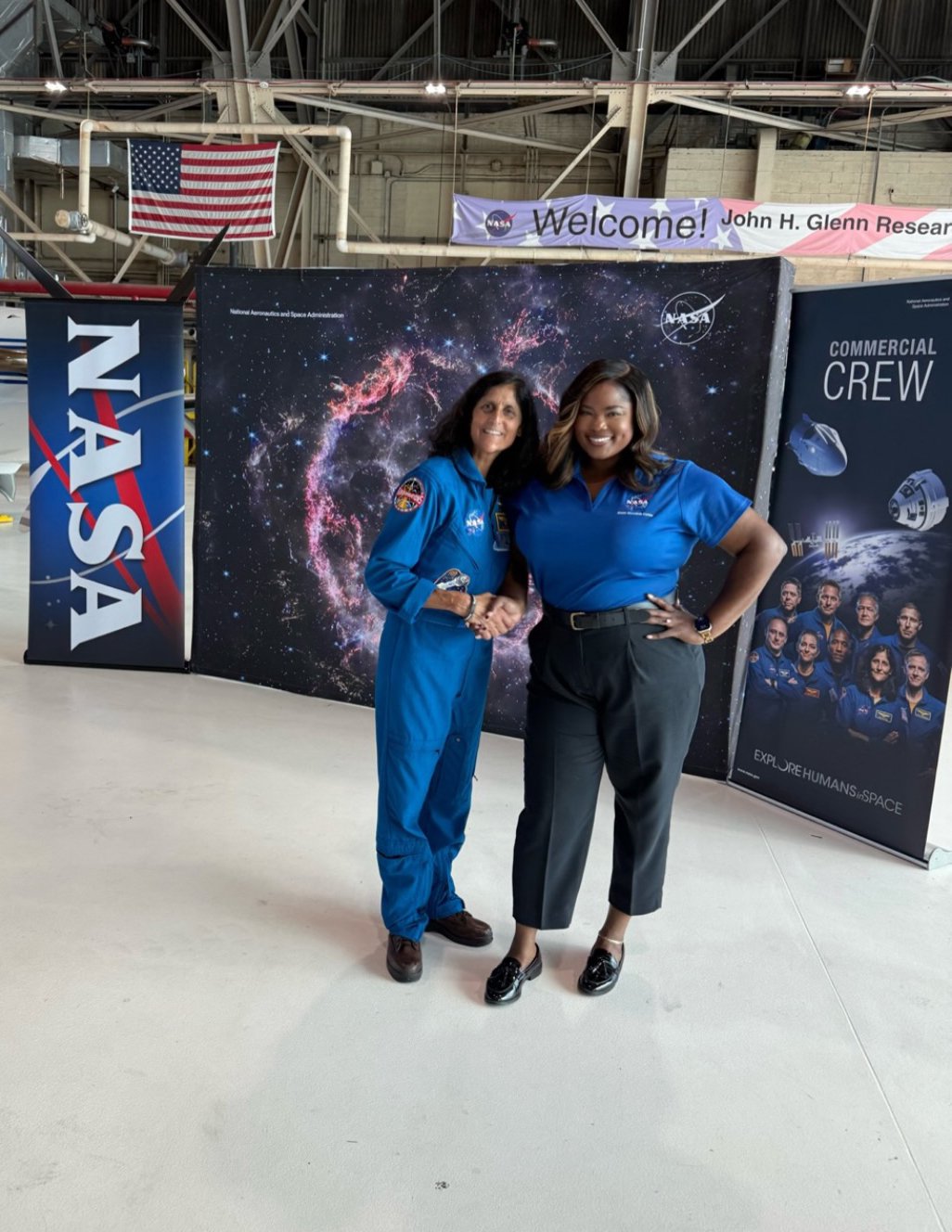 A public affairs officer poses for a photo with an astronaut.