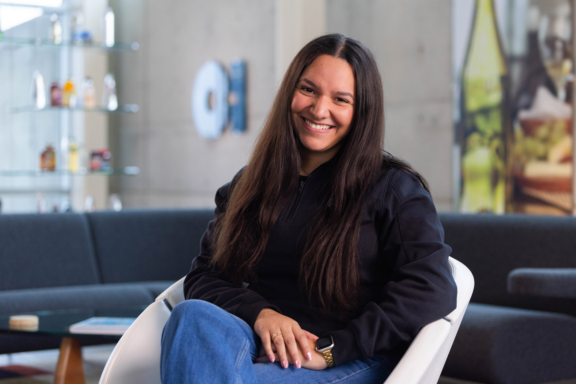 A person wearing an O-I shirt sits in the company's lobby