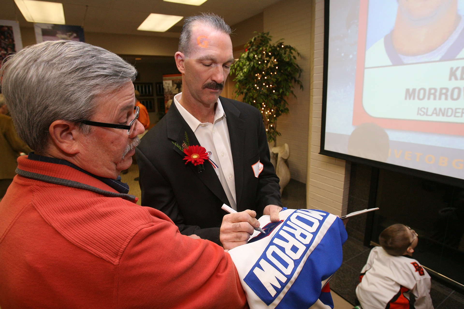 A person signs a hockey jersey.