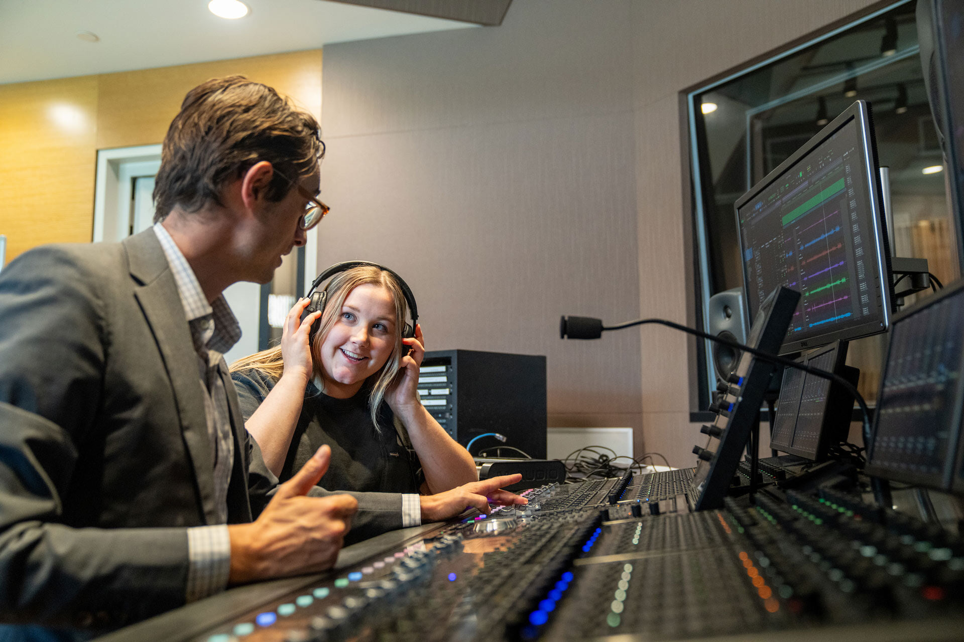Two people work on a soundboard