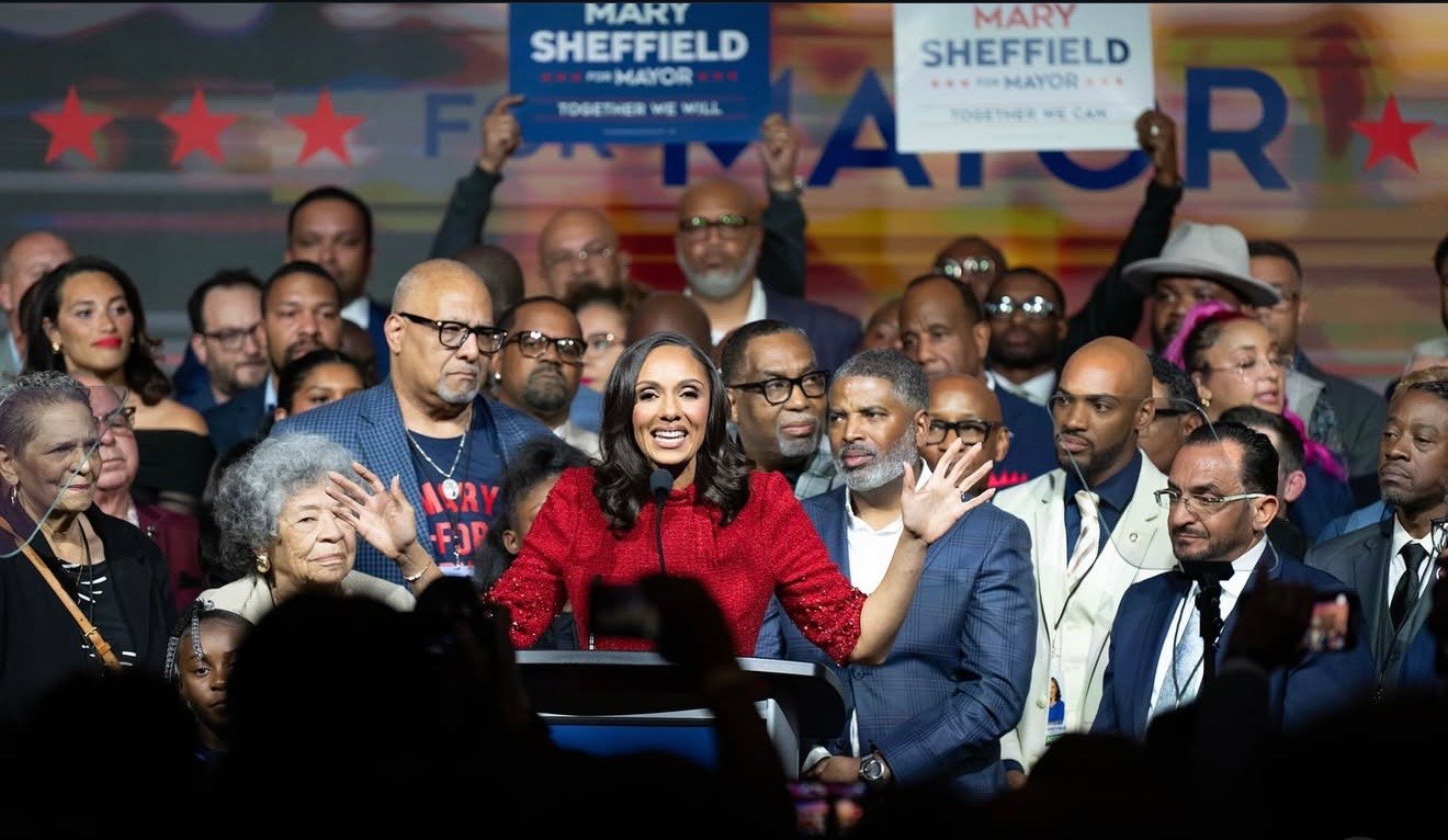 Detroit Mayor Mary Sheffield gives a speech on stage with people behind her