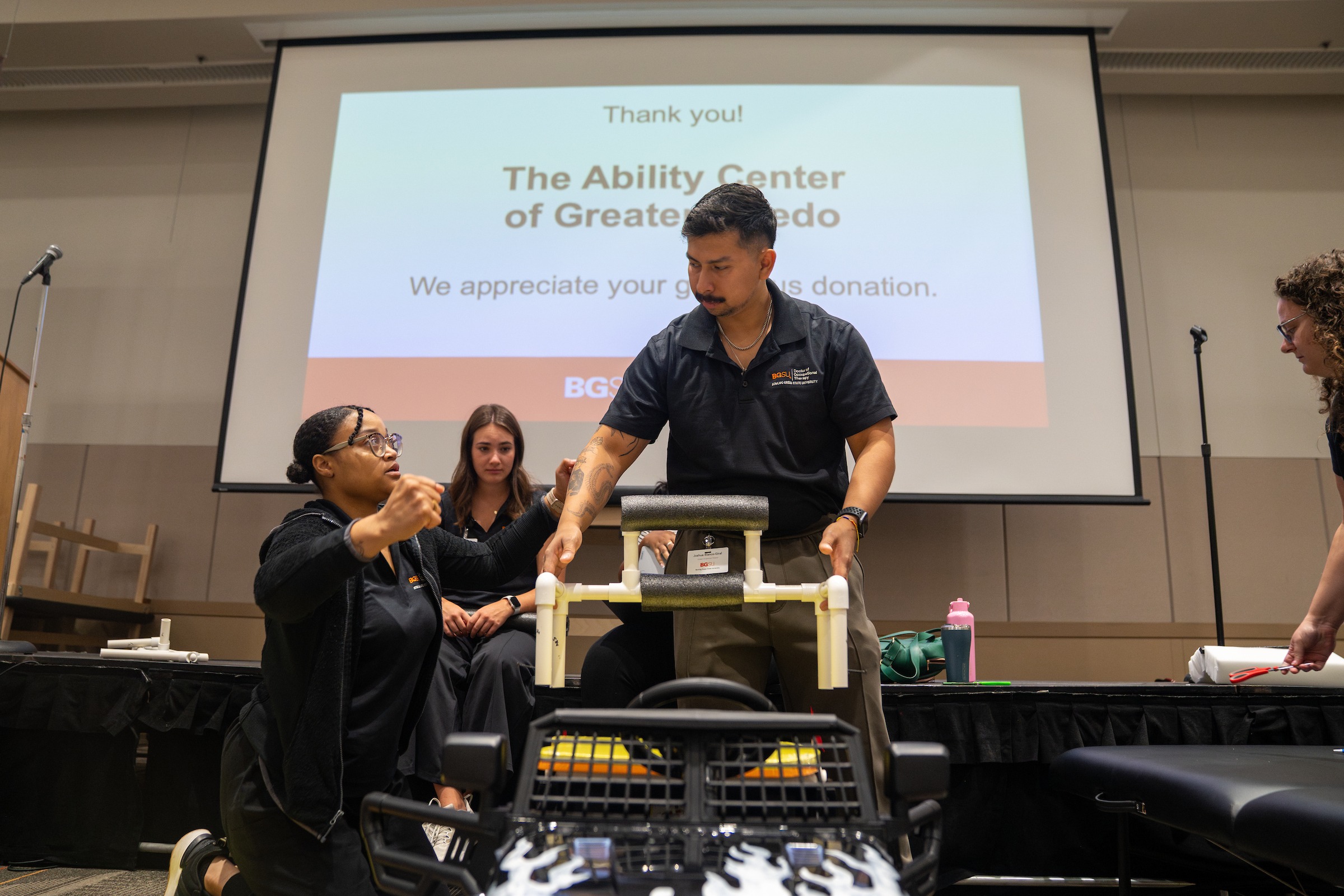 Students install a back support brace on a battery-powered vehicle.