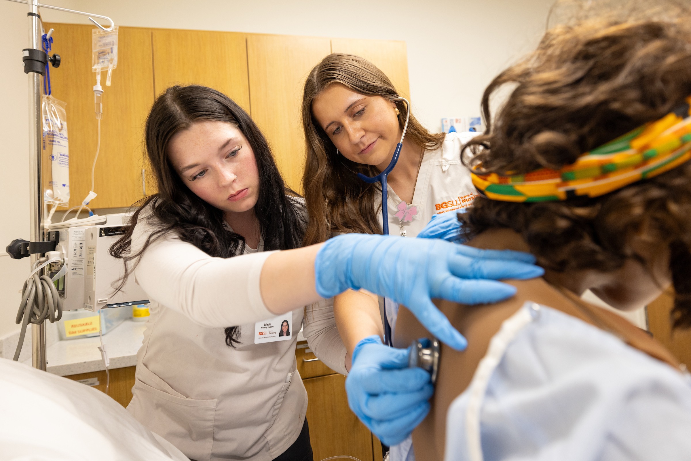 Two nursing students practice in a simulation lab