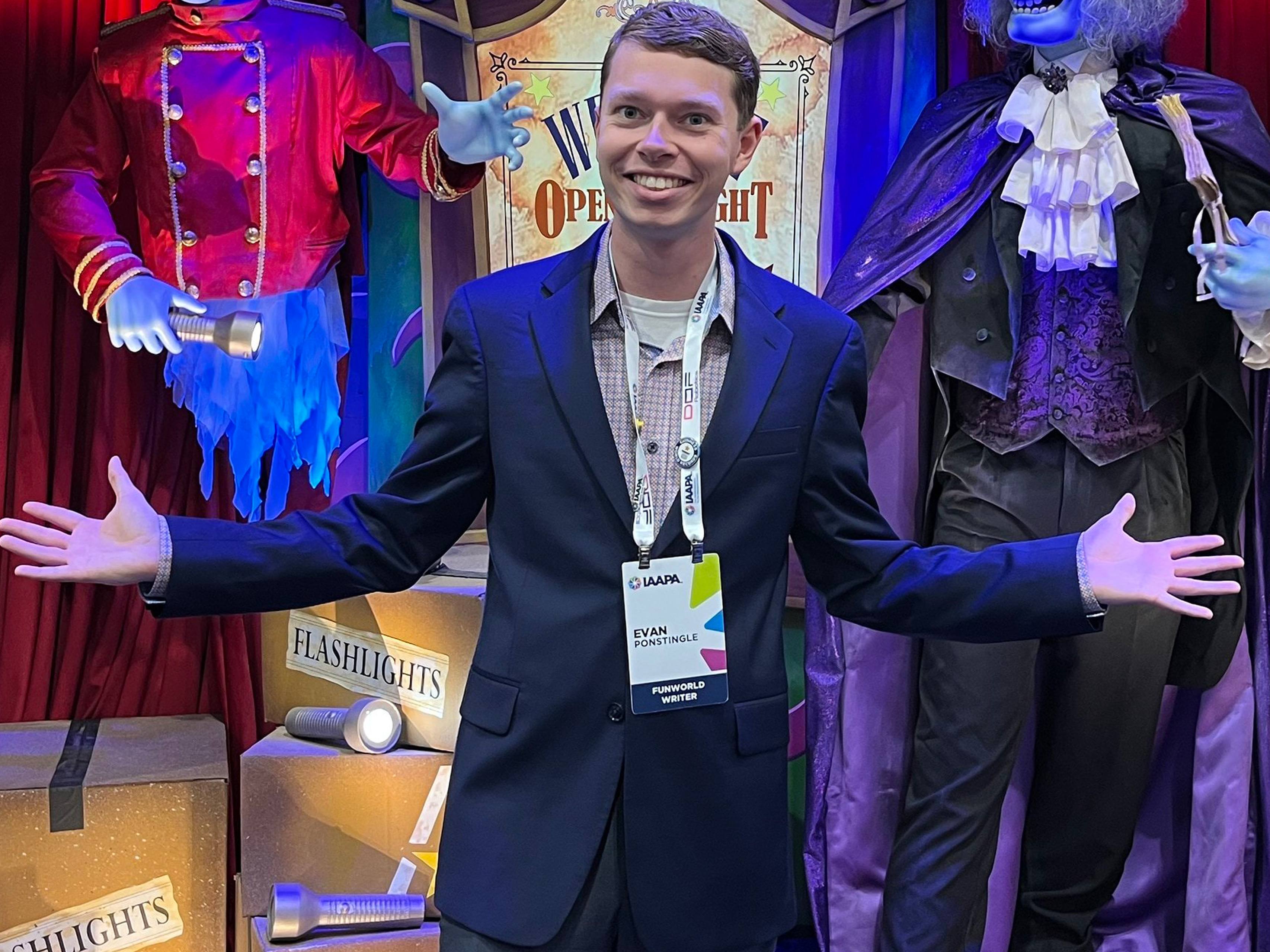 A person poses for a picture in front of "Phantom Theater" animatronics.