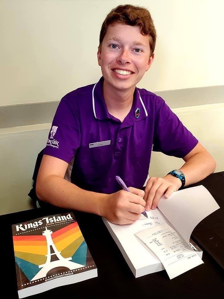 A person signs a book.