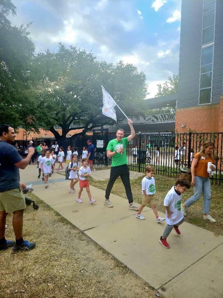 A teacher walks with a class of kindergartners.