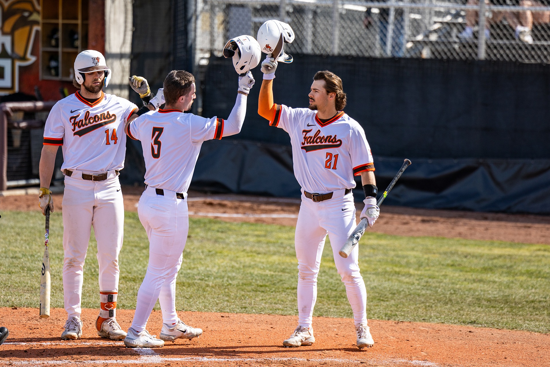 Baseball players celebrate at home plate.