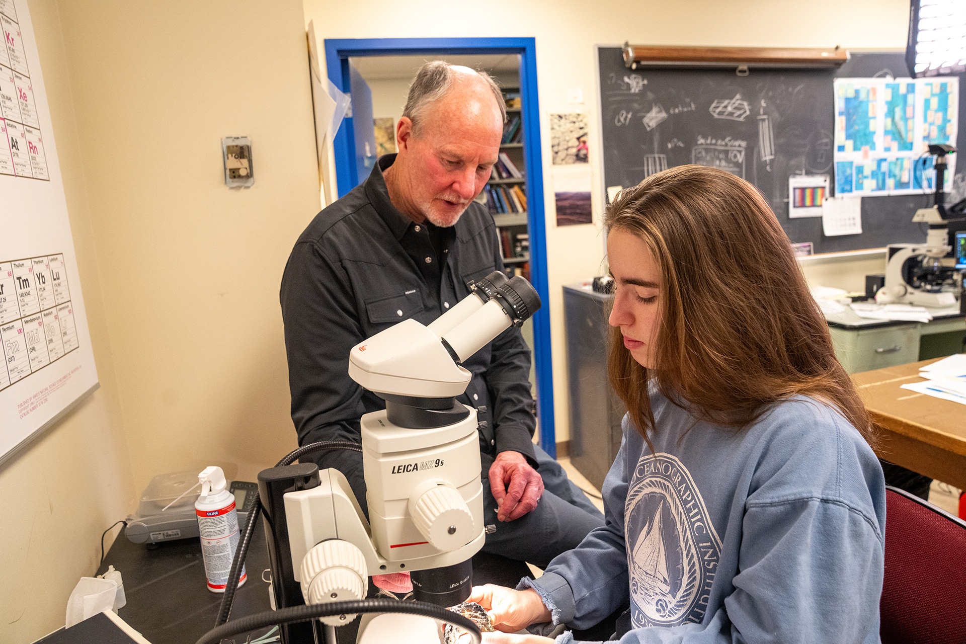 Two scientists look at a rock sample.