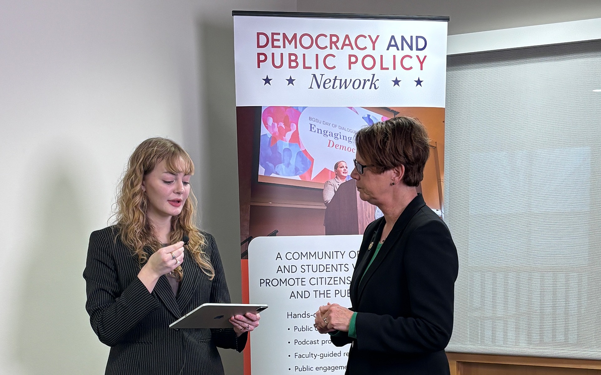 Two people conduct a news interview