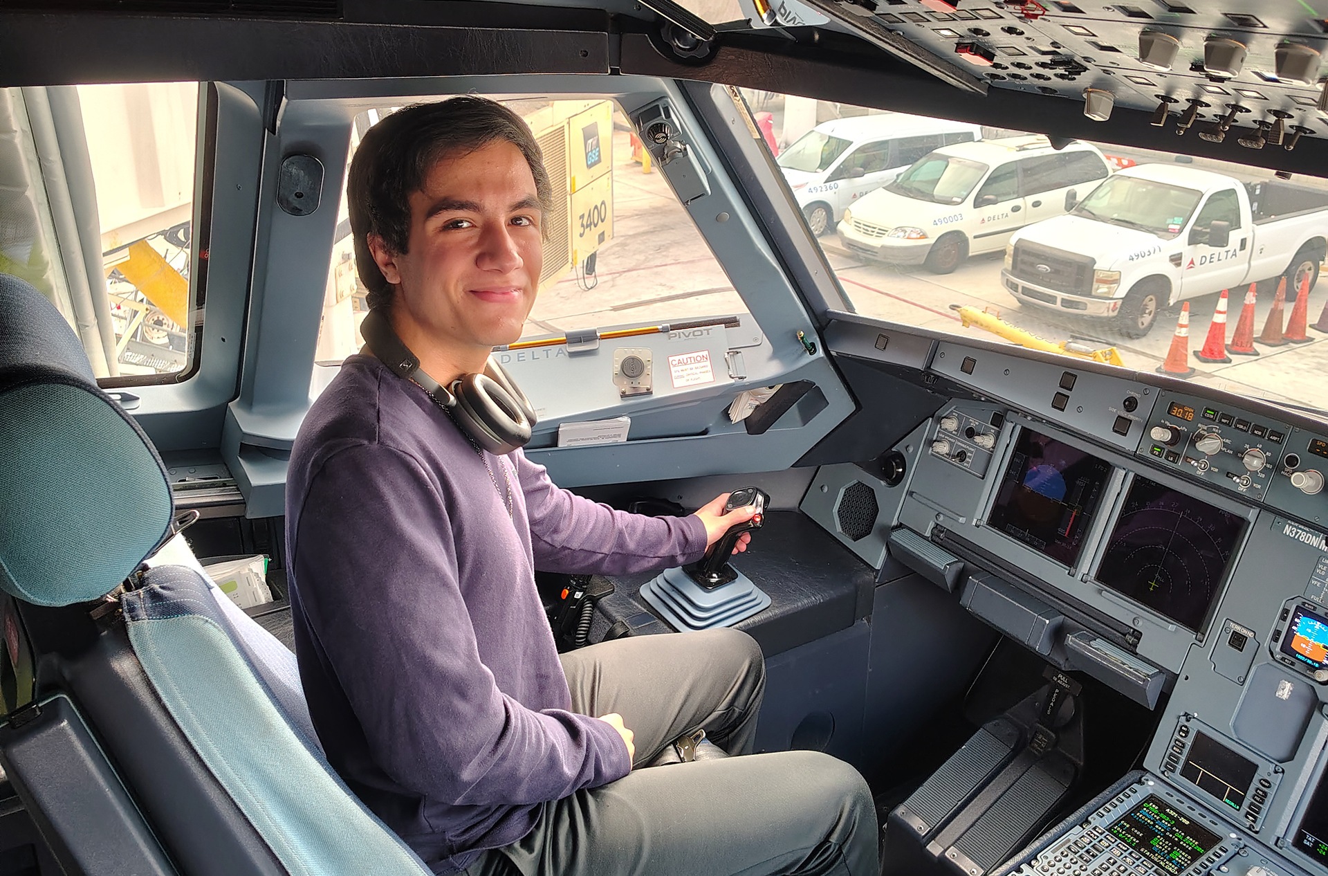 A pilot sits in a plane cockpit