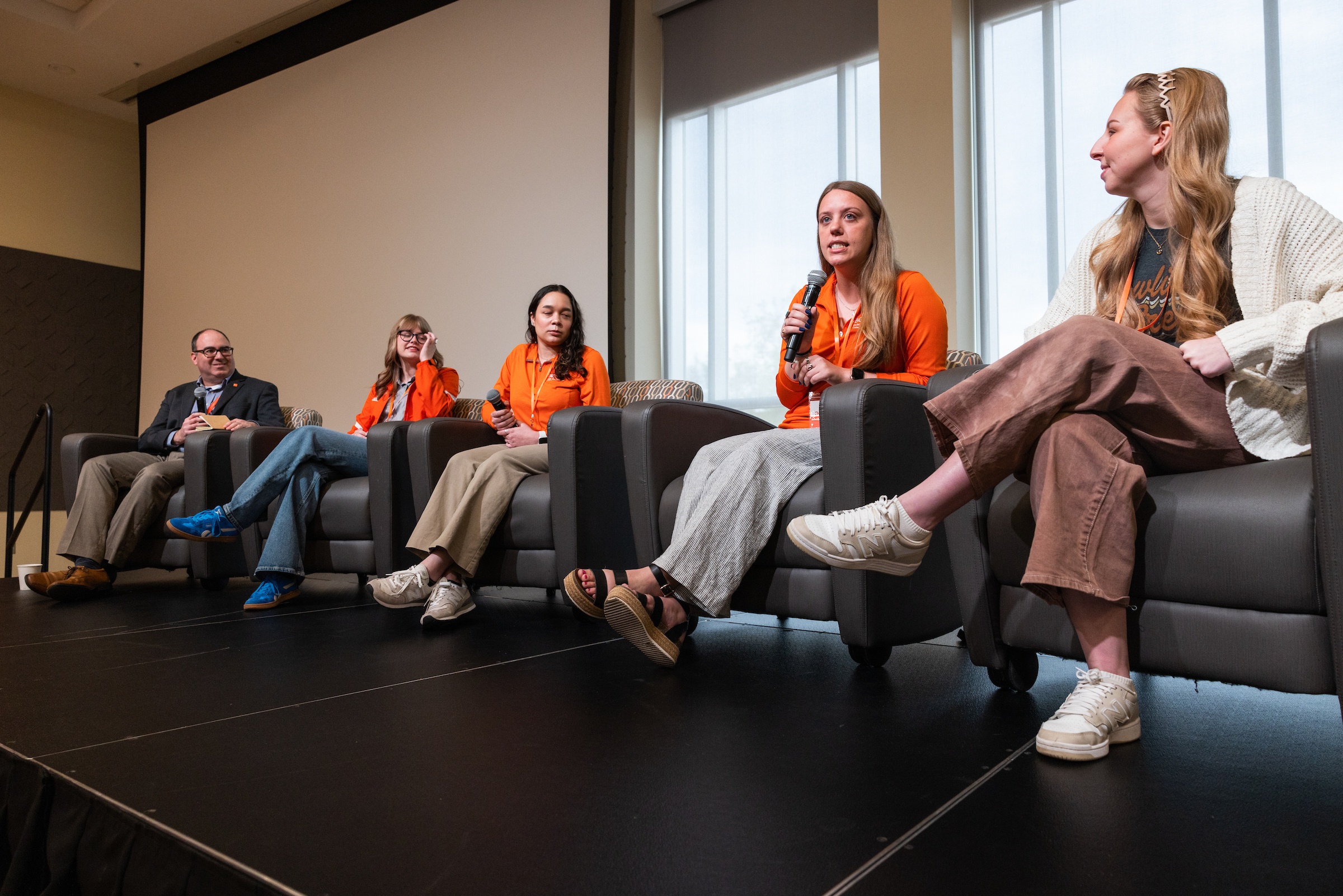 A panel of students presents on stage