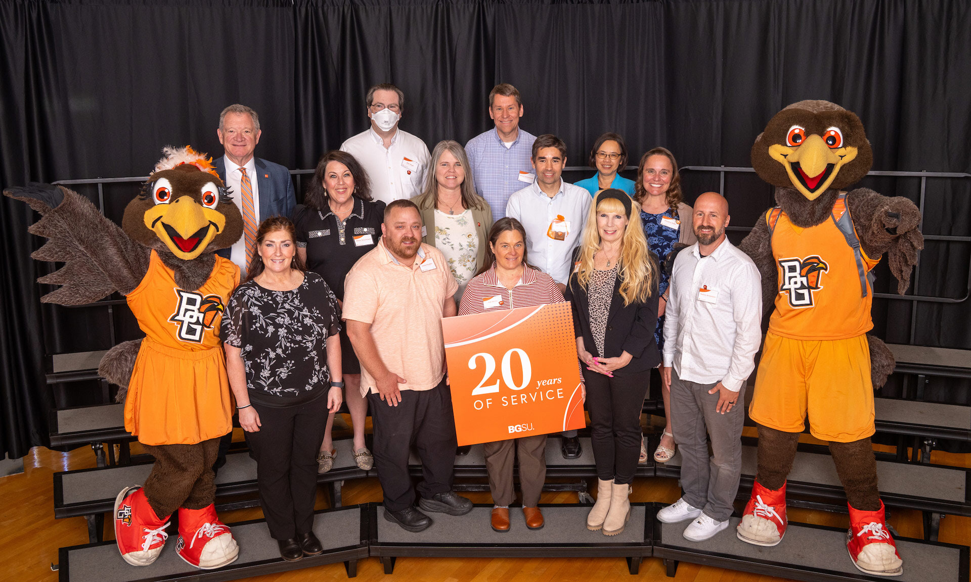 BGSU employees hold a sign with text that reads: 20 years of service