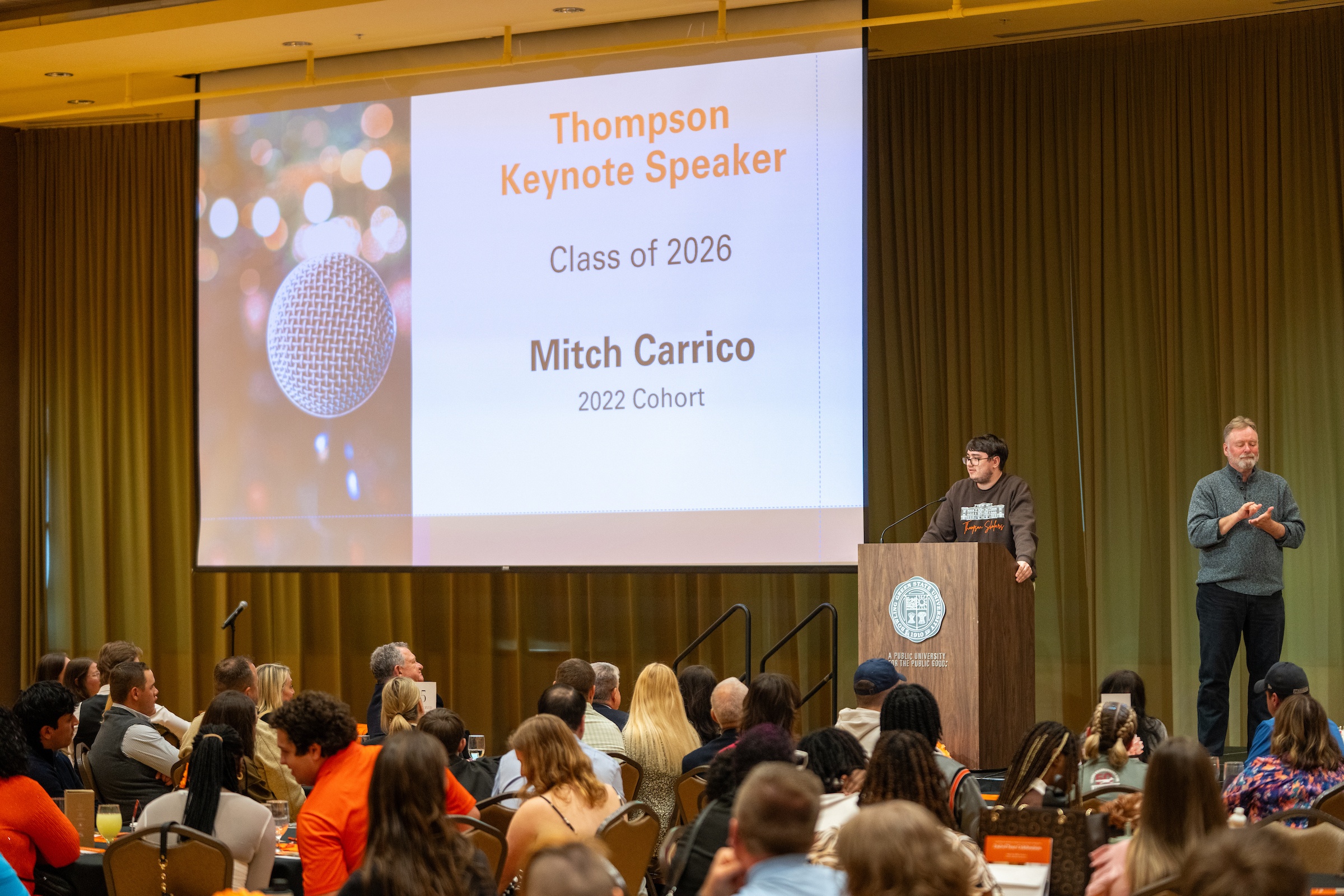 A person addresses a large conference room. 