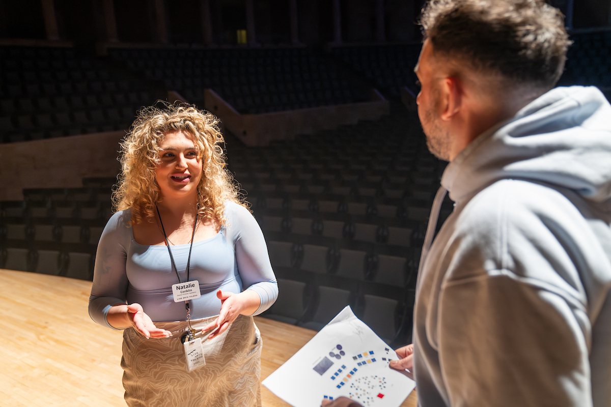 Two people stand on a stage 