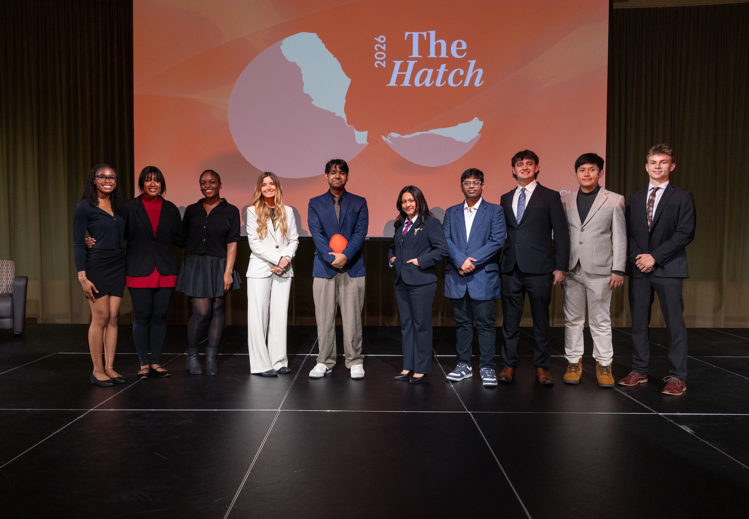A group of BGSU students on stage in front of a screen that reads: The Hatch