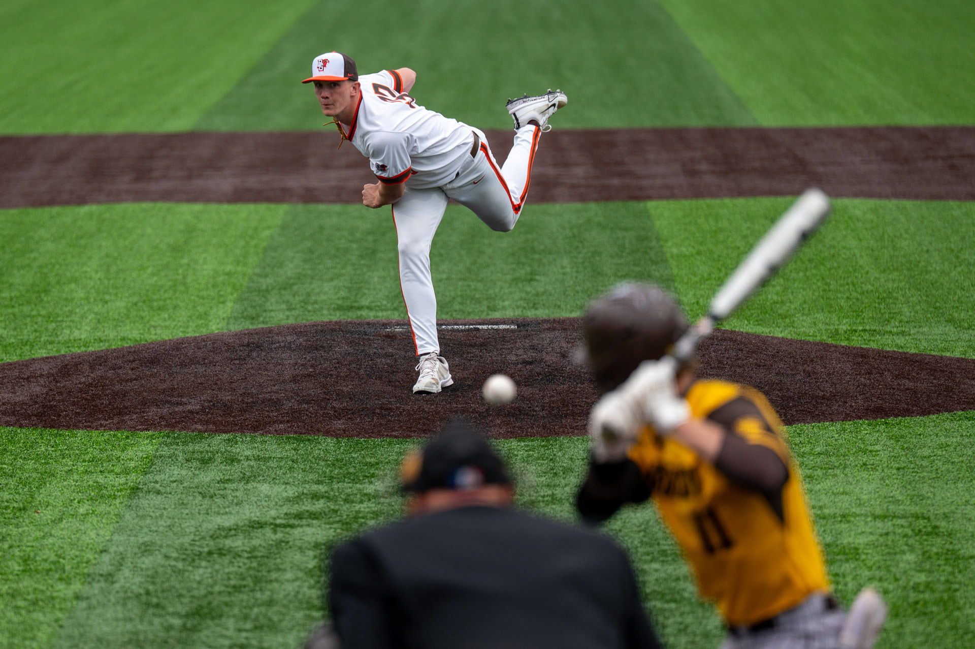 A pitcher follows through on a pitch to a left-handed batter.