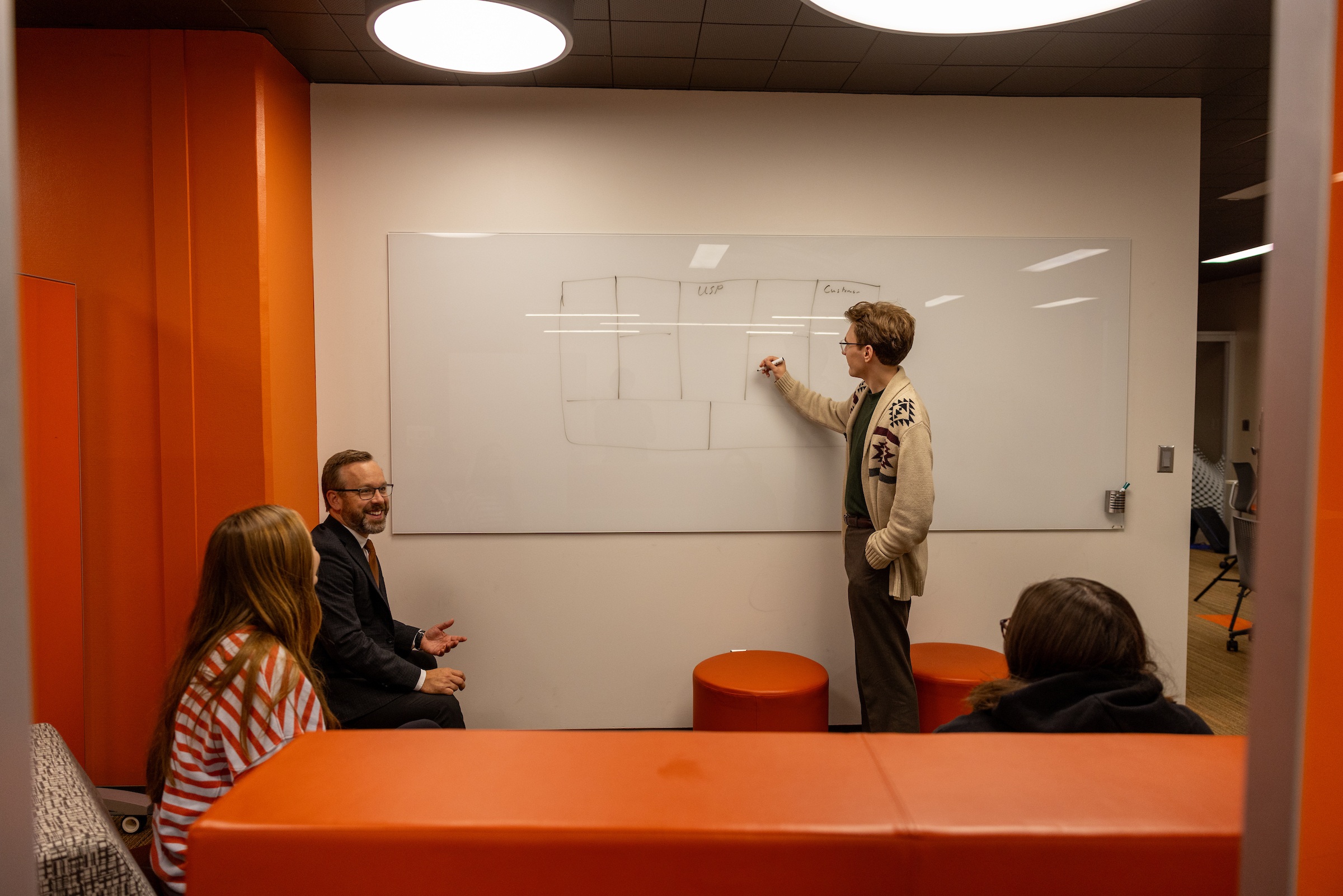 A student writes on a whiteboard.