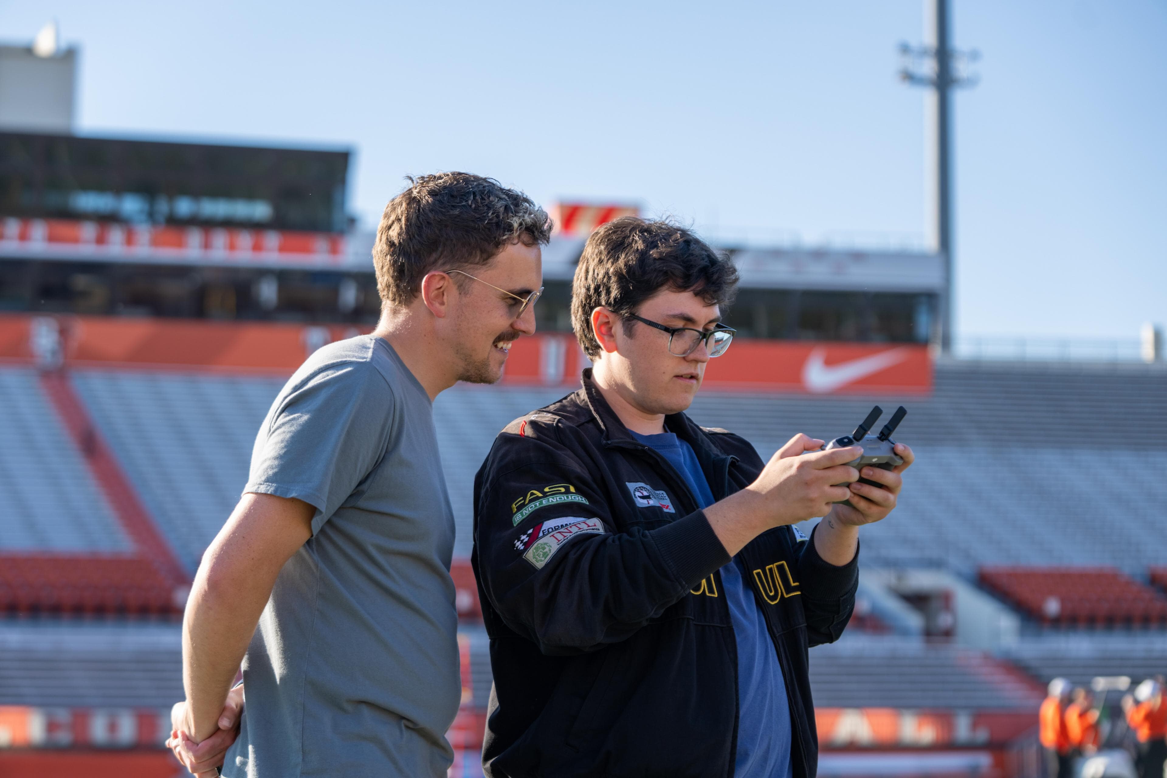 Two people look at a drone controller