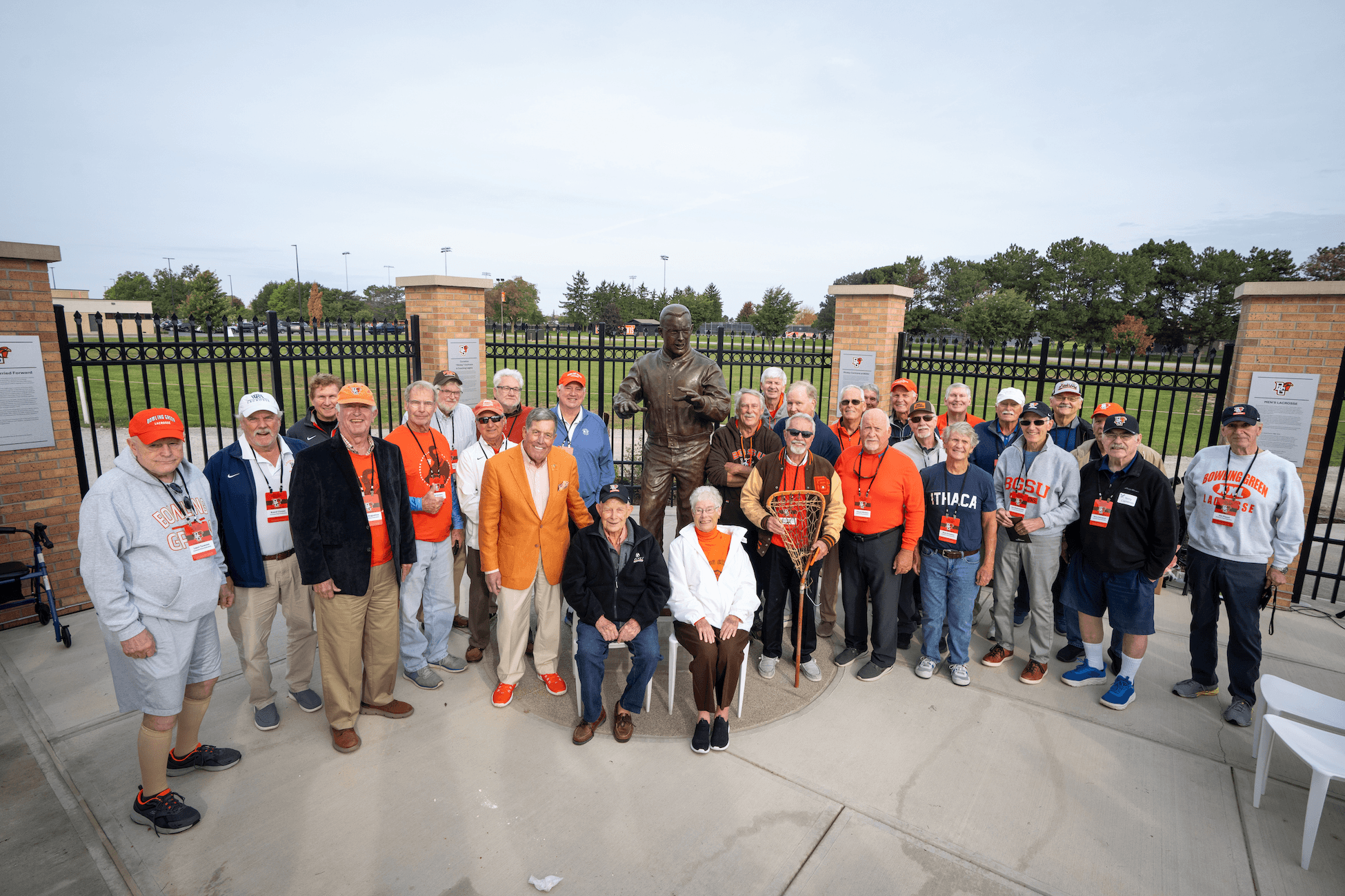 People pose for a photo in front of a new statue.