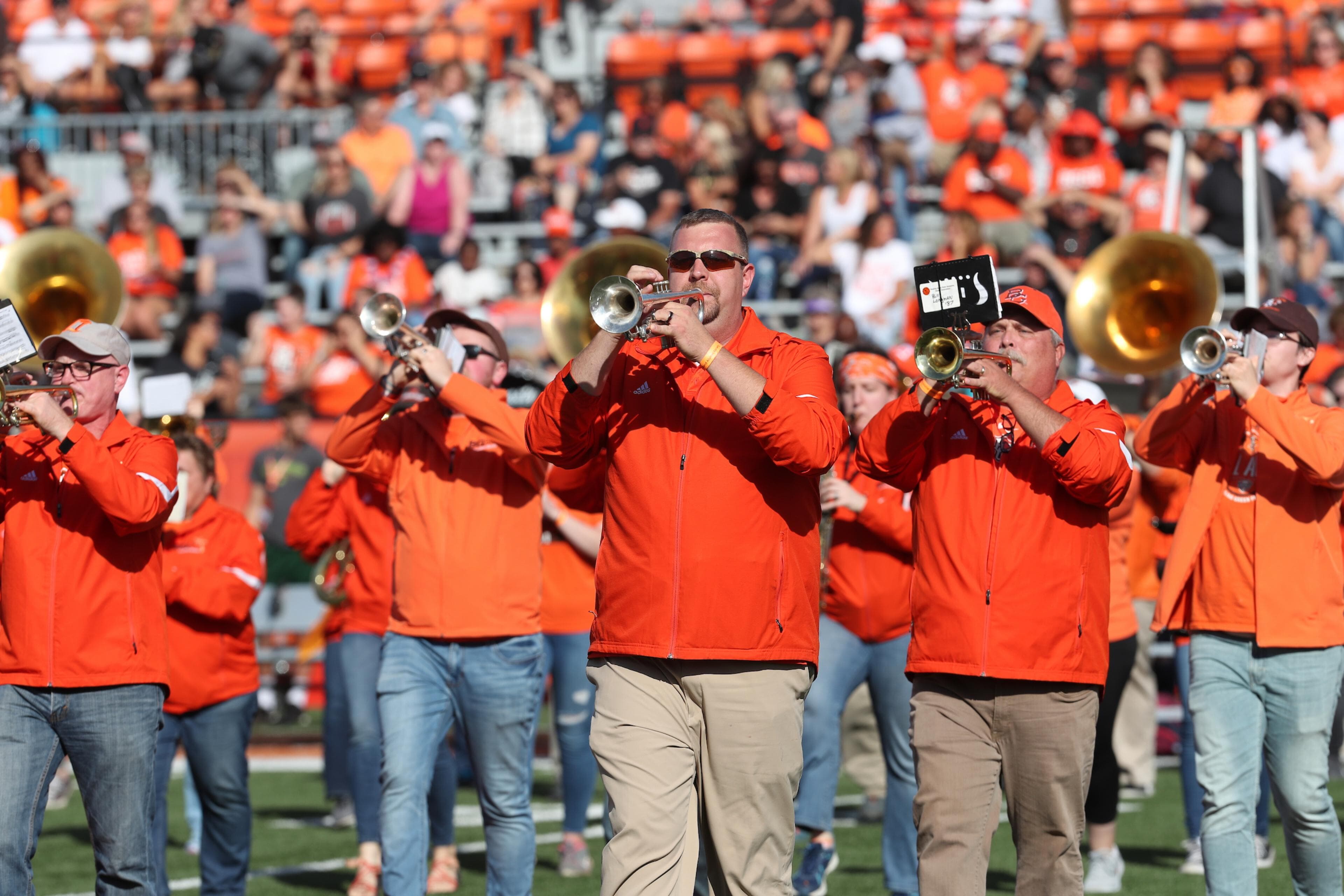 Alumni band members perform on the field