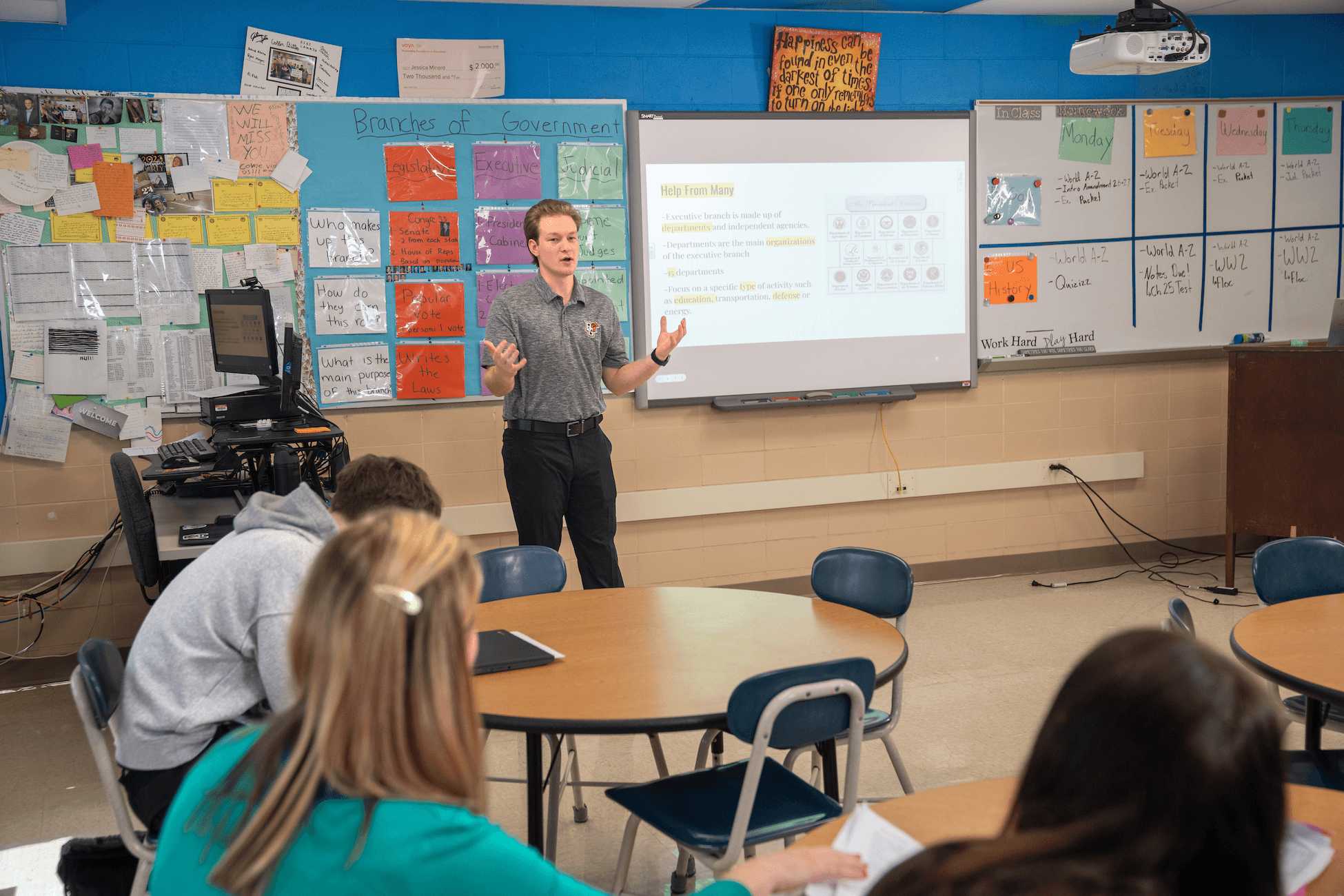 A student teacher talks in front of the classroom.