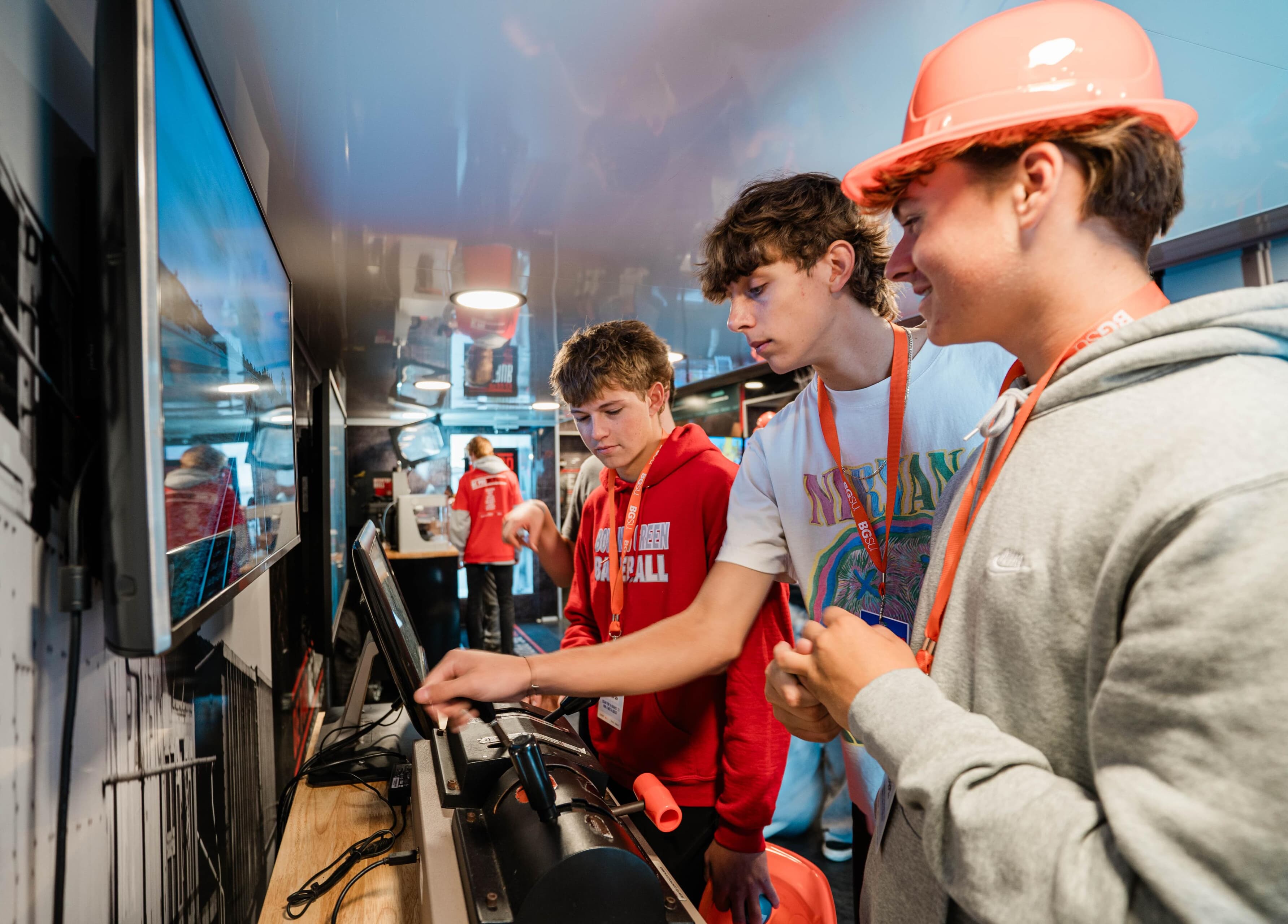 Three students look at a screen