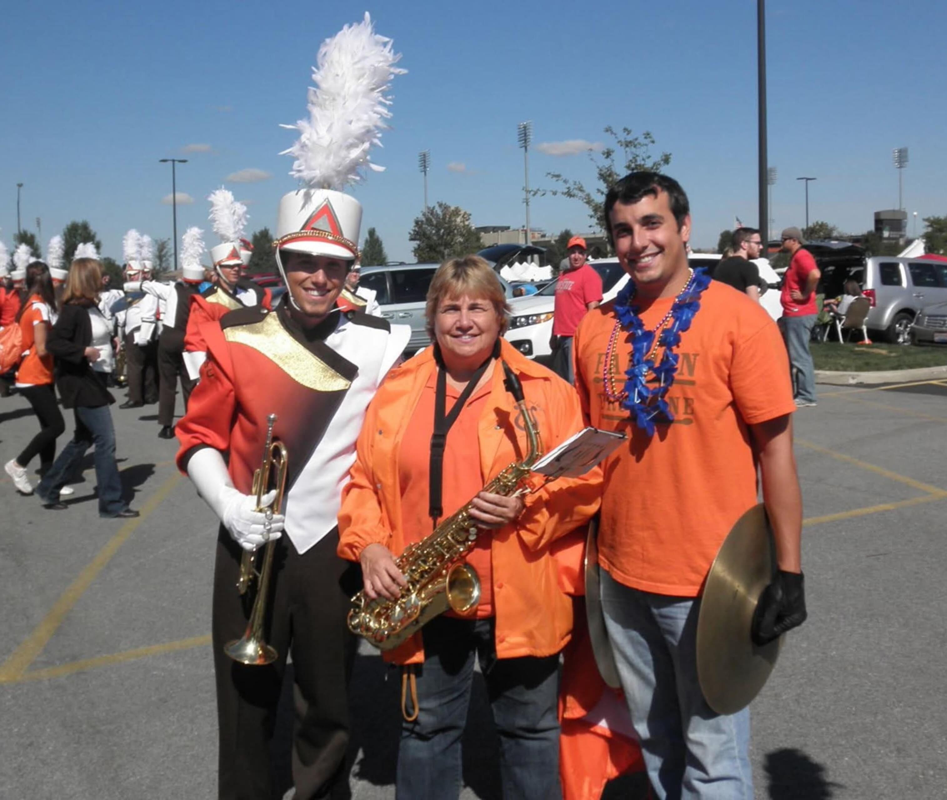 Three people holding instruments pose for a photo