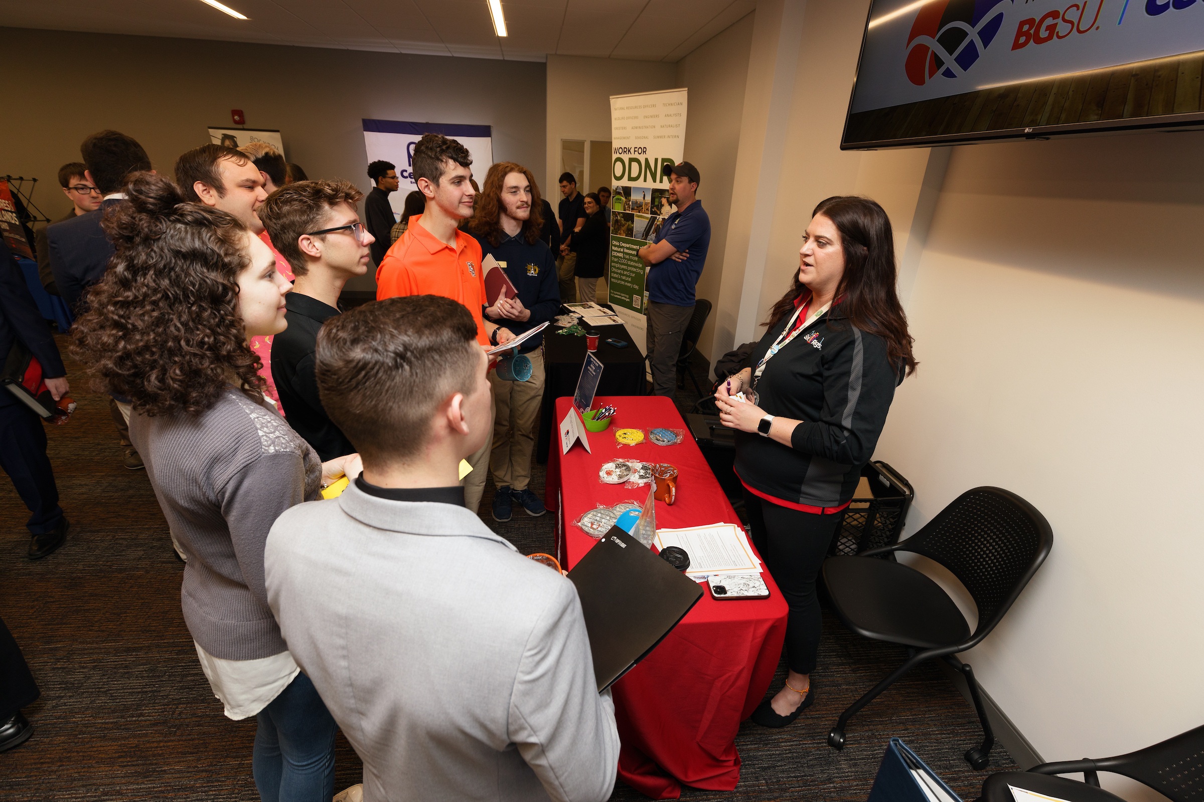 People stand around a table at a career fair.
