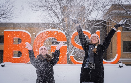 Two students throwing snow