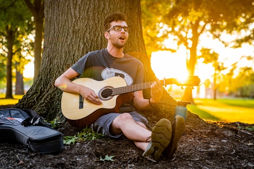 An individual playing guitar outside