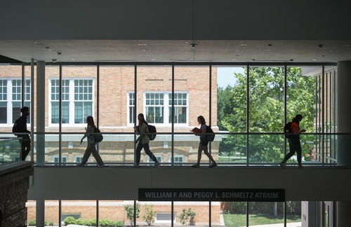 Five students walking indoors