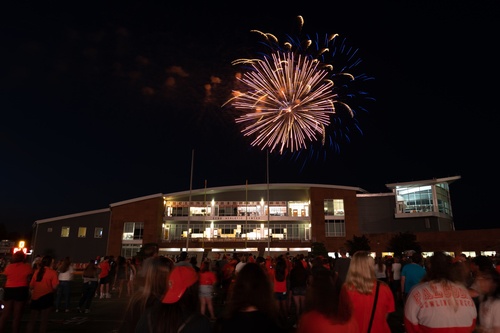 Crowd on football field watches fireworks over the Sebo Center 