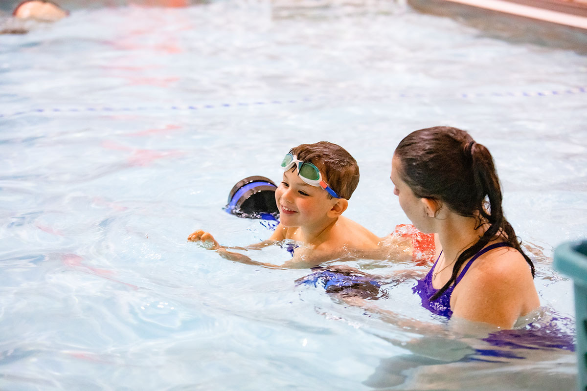 woman giving swim lessons to a young child in the pool