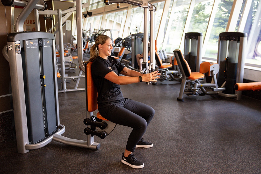 Woman doing chest flies using a pec fly machine
