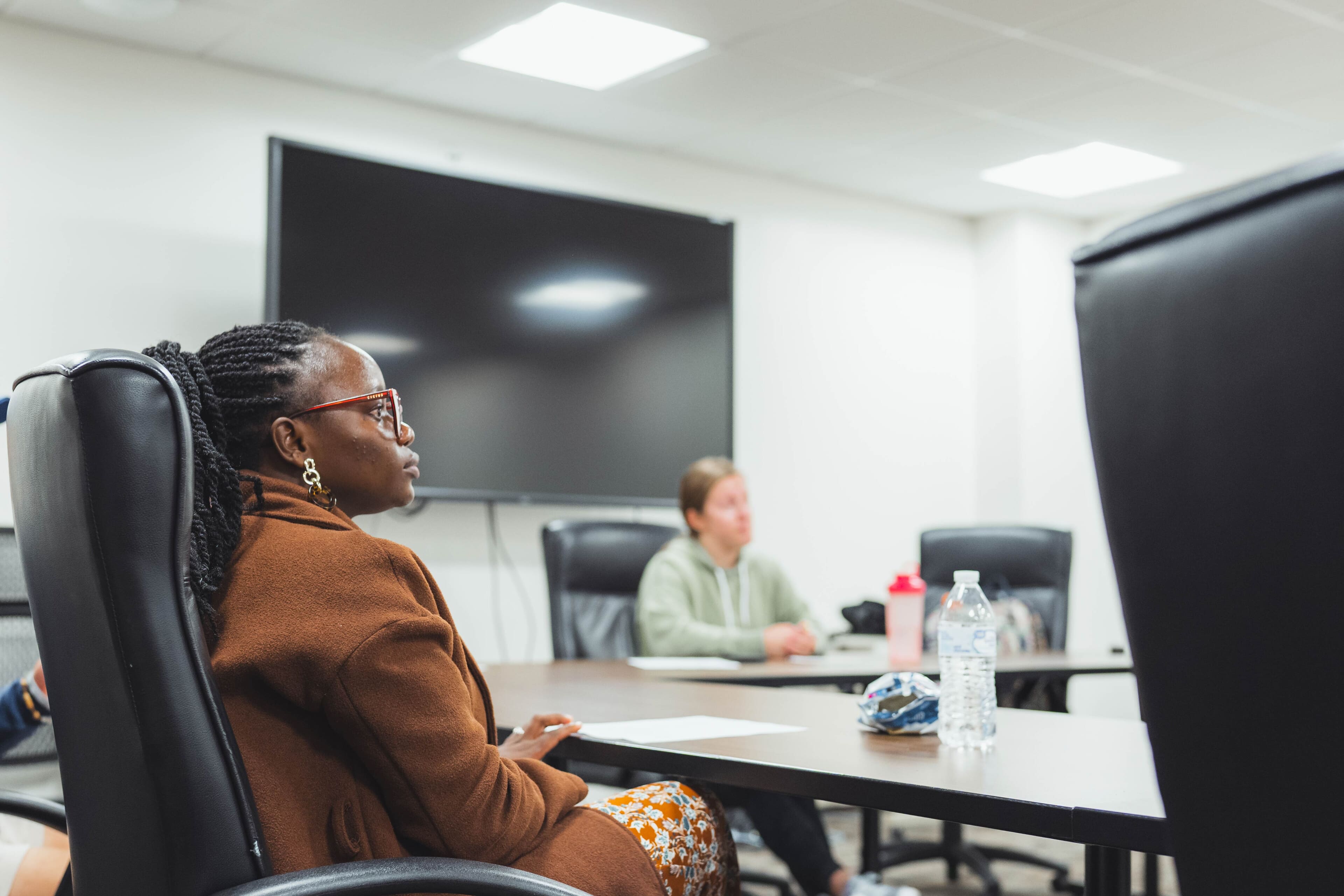 woman sitting at table listening to a mental well-being training
