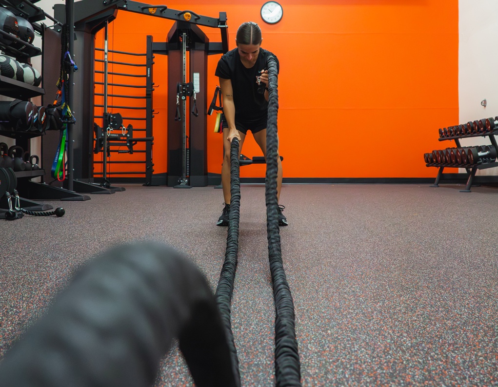 Person using battle ropes in functional training studio