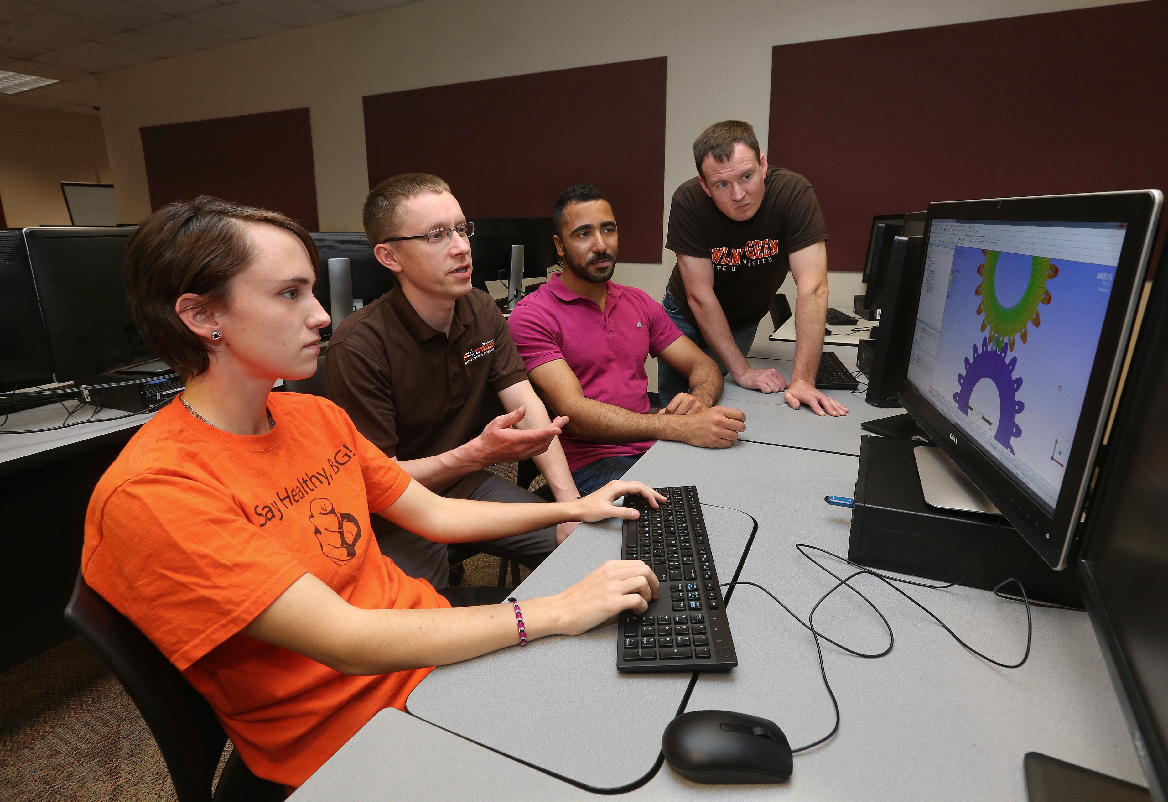 Three male and one female in the master’s program in the BGSU technology management program with a focus in quality systems work together in front of a computer.
