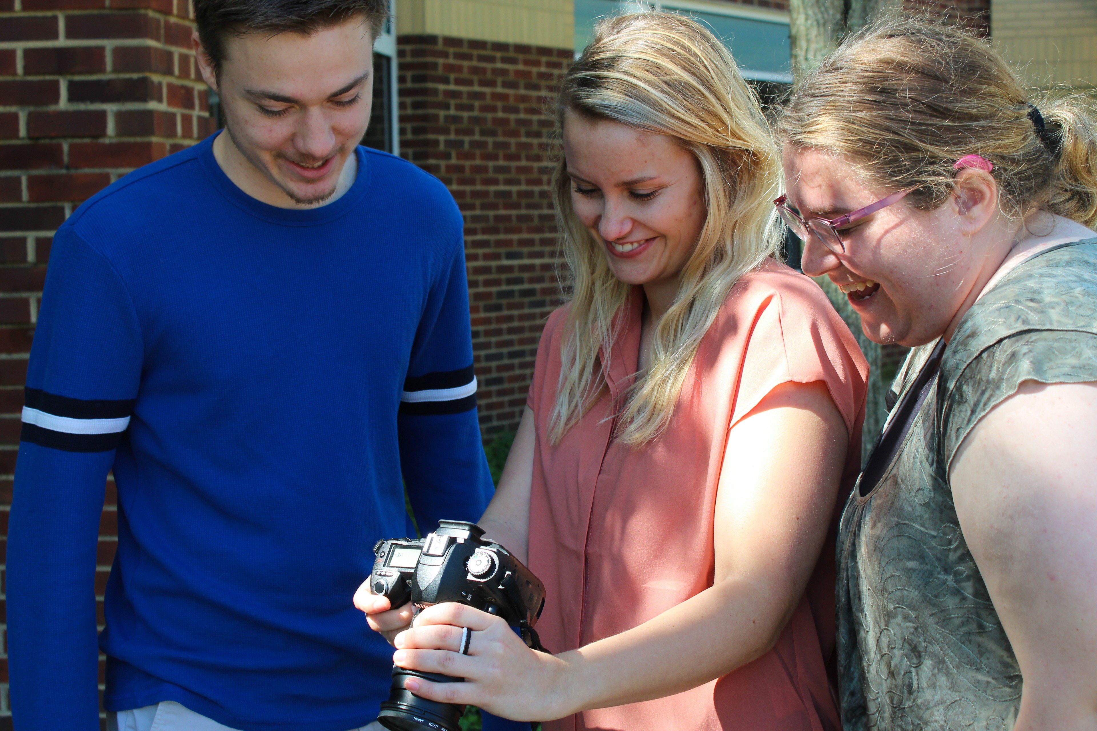 Three BGSU students looking at a photo taken on a DSLR camera
