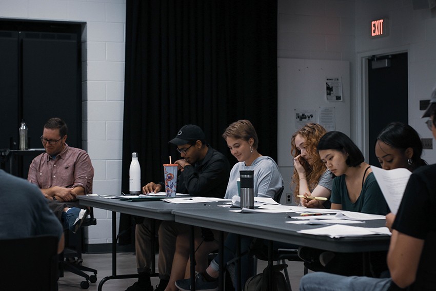 film students reading screenplays at a table