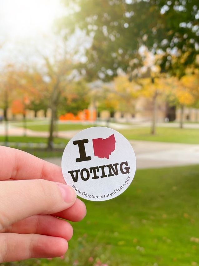 'I heart voting' sticker with the heart being the shape of ohio holder of sticker is on BGSU campus near the statue of BGSU letters